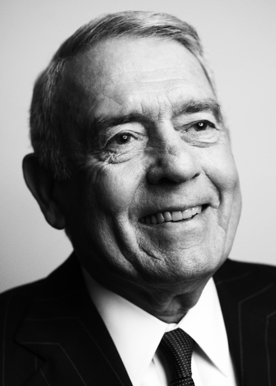 Black and white headshot in a suit and tie