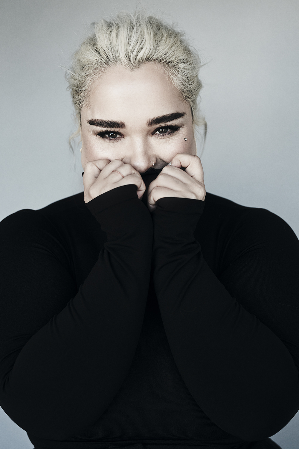 Playful portrait holding a black sweater near the face